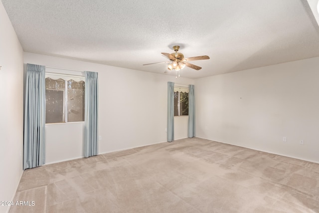 carpeted spare room with a textured ceiling and ceiling fan