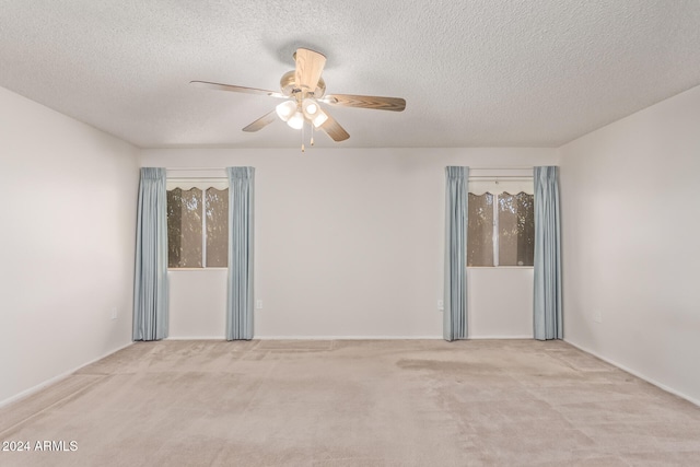 carpeted spare room featuring ceiling fan and a textured ceiling