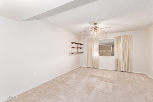 empty room featuring light carpet, a textured ceiling, and ceiling fan