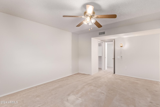 carpeted empty room with a textured ceiling and ceiling fan