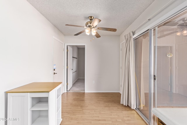 hall featuring a textured ceiling and light wood-type flooring