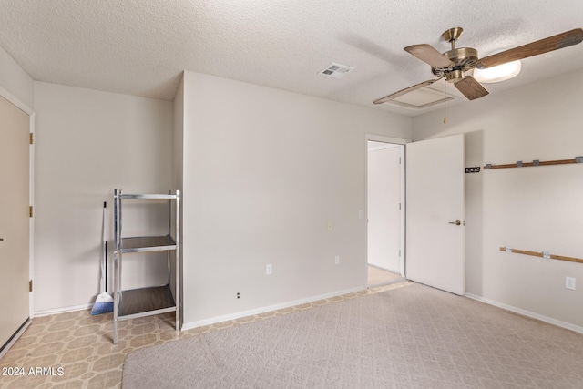 unfurnished bedroom with a textured ceiling, light colored carpet, and ceiling fan