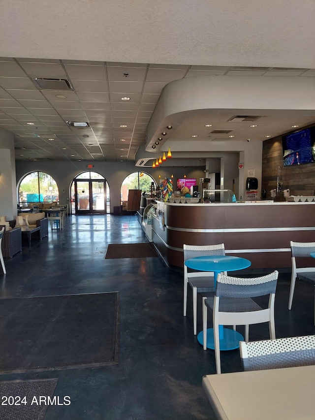 interior space featuring a paneled ceiling and concrete flooring