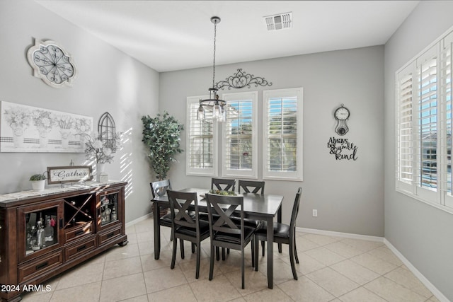 tiled dining area with plenty of natural light and a notable chandelier