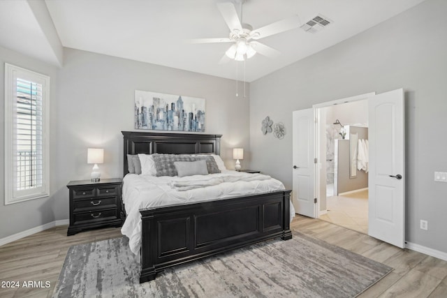 bedroom featuring light hardwood / wood-style floors, ceiling fan, and connected bathroom