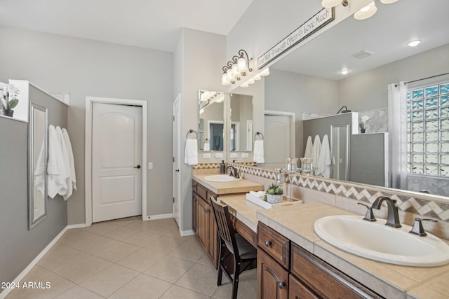 bathroom featuring vanity, tile patterned floors, backsplash, and a shower