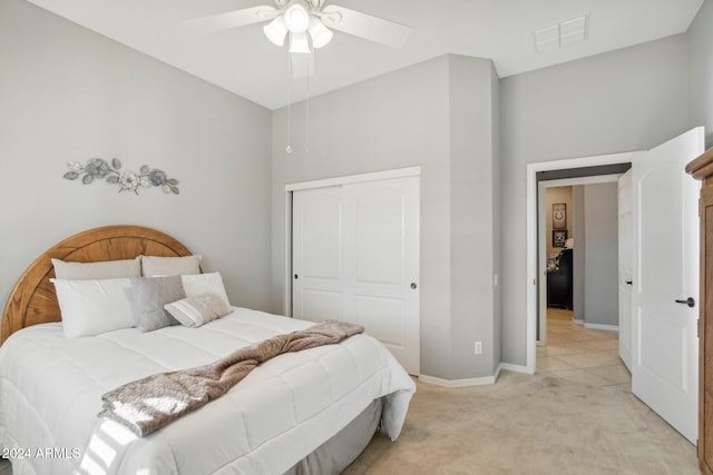 bedroom with a closet, light carpet, and ceiling fan