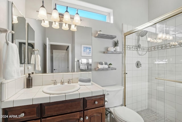 bathroom featuring toilet, vanity, and walk in shower