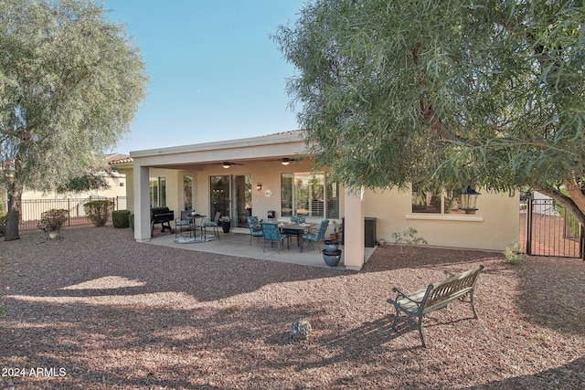 rear view of property featuring ceiling fan and a patio area