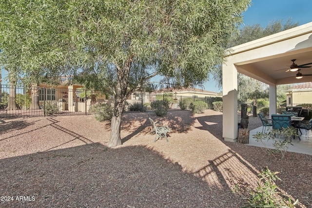 view of yard with ceiling fan and a patio