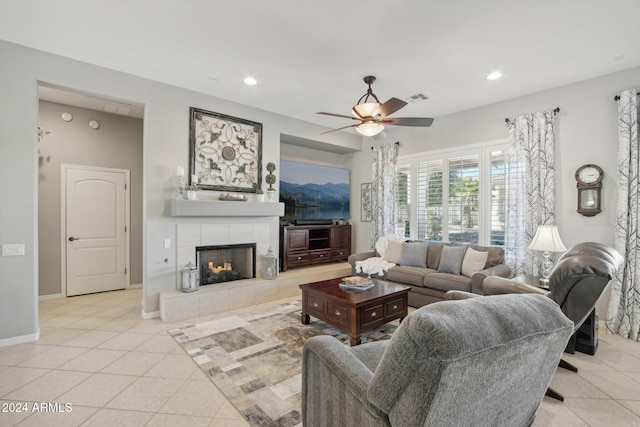 tiled living room featuring ceiling fan and a fireplace