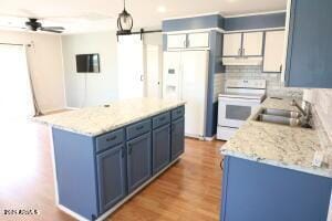 kitchen featuring decorative backsplash, sink, white appliances, hanging light fixtures, and blue cabinetry