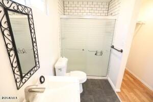 bathroom with toilet and hardwood / wood-style flooring