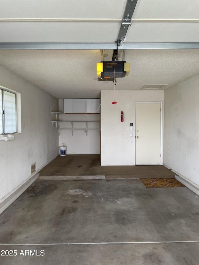 garage with visible vents and a garage door opener