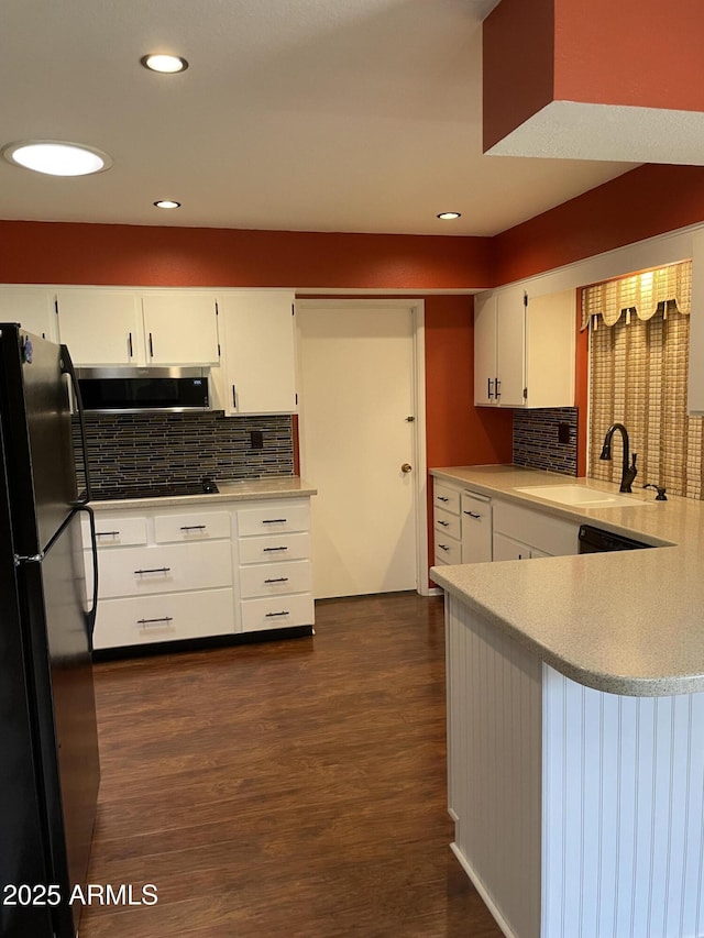 kitchen featuring dark wood-style floors, freestanding refrigerator, a sink, light countertops, and white cabinetry