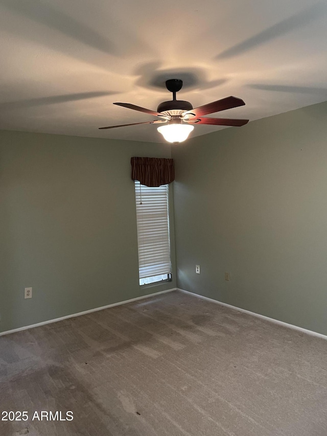 carpeted empty room with baseboards and a ceiling fan