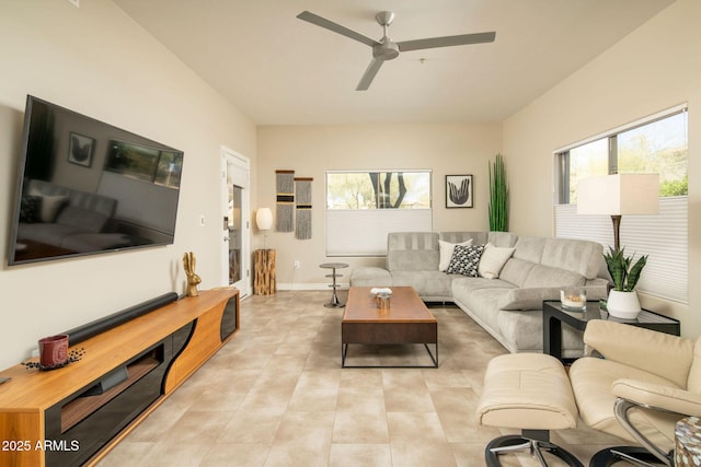 living area with light tile patterned floors, baseboards, and ceiling fan