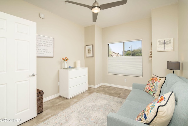 living area with light tile patterned floors, baseboards, and ceiling fan