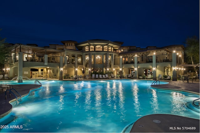 pool at twilight with a community pool and a patio area