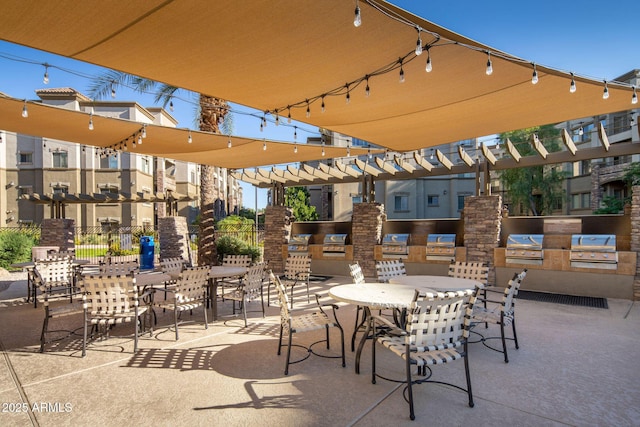view of patio featuring an outdoor kitchen, outdoor dining area, and a grill