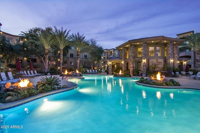 community pool with a fire pit and a patio area