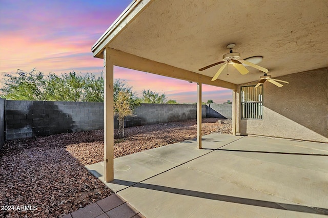 patio terrace at dusk featuring ceiling fan