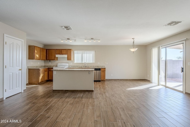 kitchen with white stove, hardwood / wood-style flooring, stainless steel dishwasher, and a kitchen island