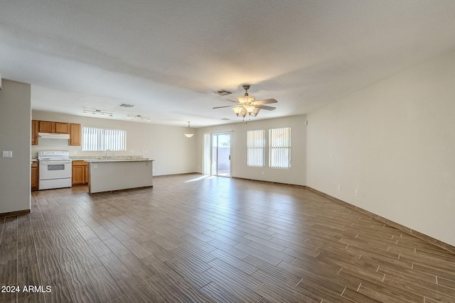 unfurnished living room featuring a textured ceiling, ceiling fan, sink, and dark hardwood / wood-style floors