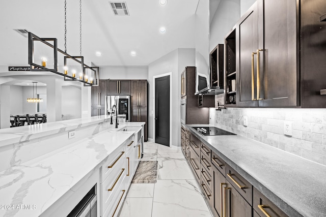 kitchen with light stone countertops, sink, pendant lighting, appliances with stainless steel finishes, and dark brown cabinets