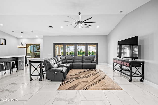 living room with lofted ceiling and ceiling fan with notable chandelier