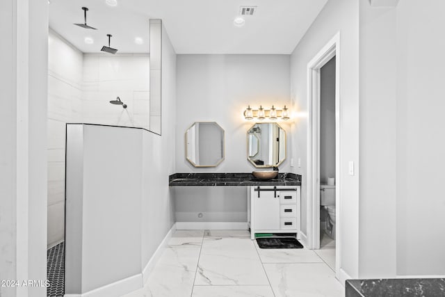 bathroom featuring walk in shower, vanity, and toilet