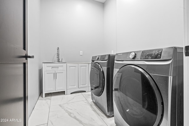 laundry area featuring washer and dryer, cabinets, and sink