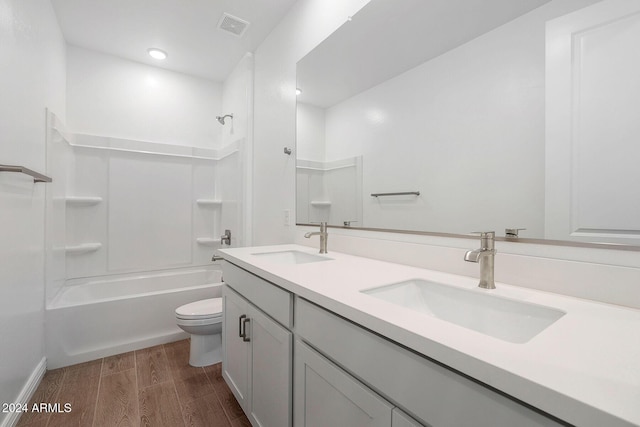 full bathroom featuring hardwood / wood-style flooring, vanity, toilet, and tub / shower combination