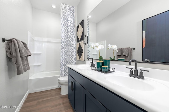 full bathroom featuring hardwood / wood-style floors, vanity, toilet, and shower / tub combination