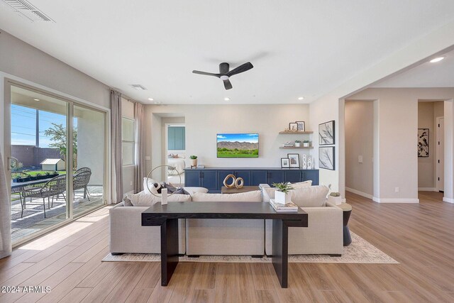 living room featuring ceiling fan and light hardwood / wood-style floors