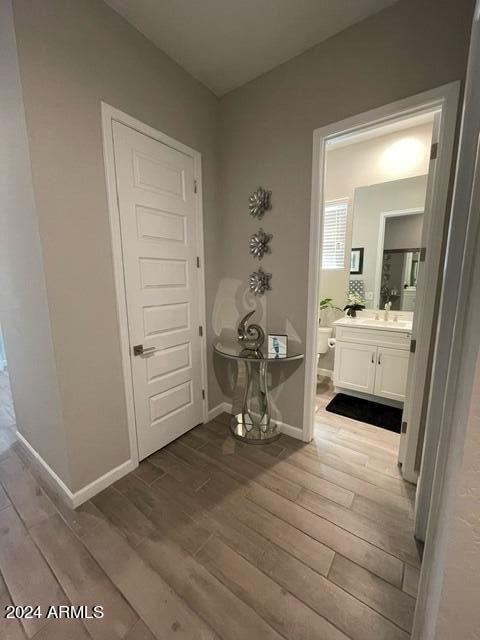 corridor featuring sink and light hardwood / wood-style floors