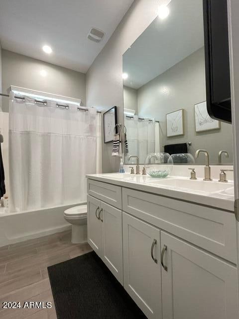 full bathroom with toilet, vanity, and shower / tub combo with curtain