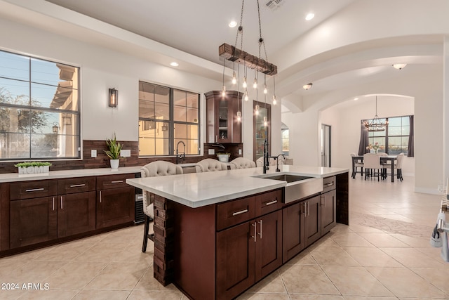 kitchen with a kitchen breakfast bar, a chandelier, pendant lighting, and tasteful backsplash