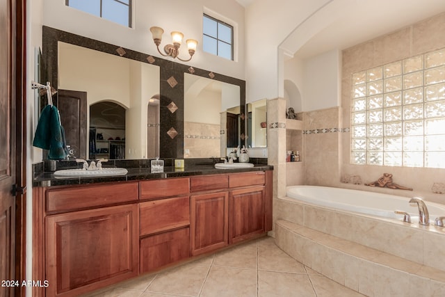 bathroom with tiled bath, vanity, a towering ceiling, and tile patterned flooring