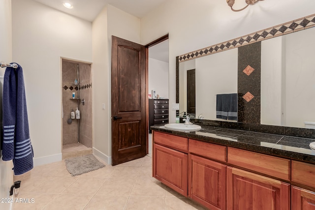 bathroom featuring a tile shower, tile patterned flooring, and vanity