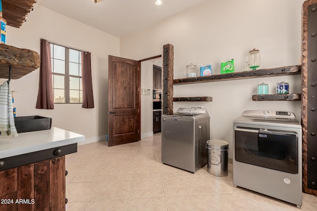 washroom with light tile patterned floors and washer and dryer