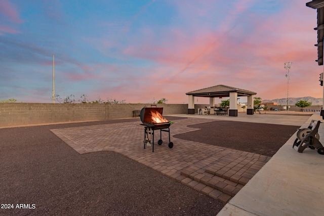 exterior space with a gazebo, a fire pit, a mountain view, and a patio area