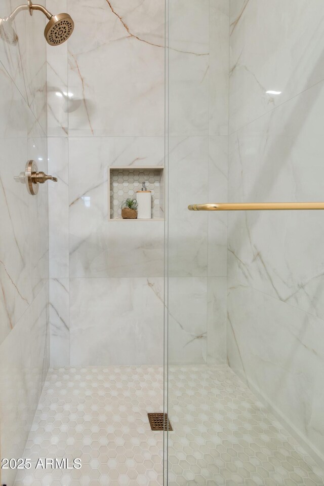 full bath featuring a marble finish shower