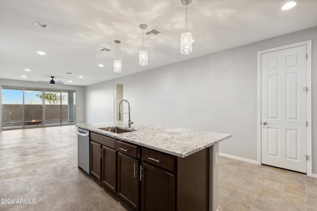 kitchen with a center island with sink, hanging light fixtures, light stone counters, stainless steel dishwasher, and sink