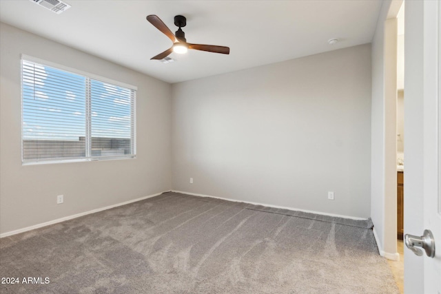 carpeted empty room featuring ceiling fan