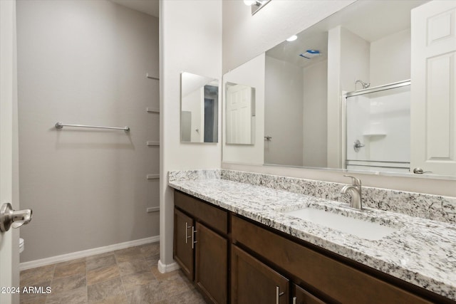 bathroom featuring vanity and a shower with shower door