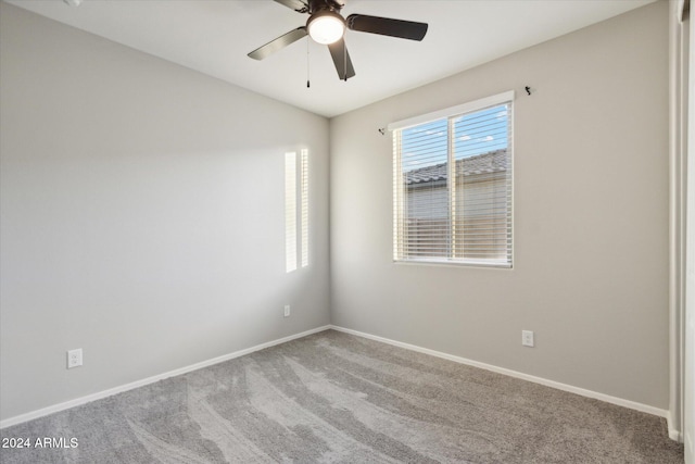 carpeted spare room featuring ceiling fan