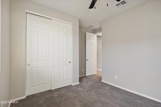 unfurnished bedroom featuring a closet, dark carpet, and ceiling fan