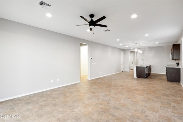 unfurnished living room featuring sink and ceiling fan