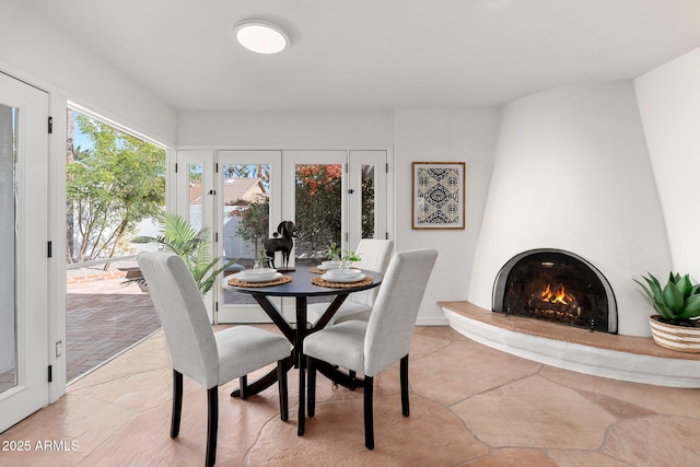 dining area with a large fireplace and french doors